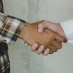 oman expat giving shake hand to Omani after money exchange