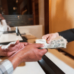 A customer receiving Indian rupee notes at a money exchange counter, representing money transfer from Oman to India with secure and reliable service.